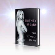 Hardcover copy of "The Woman in Me" by Britney Spears, featuring a close-up of the book cover with Britney Spears' image and title.