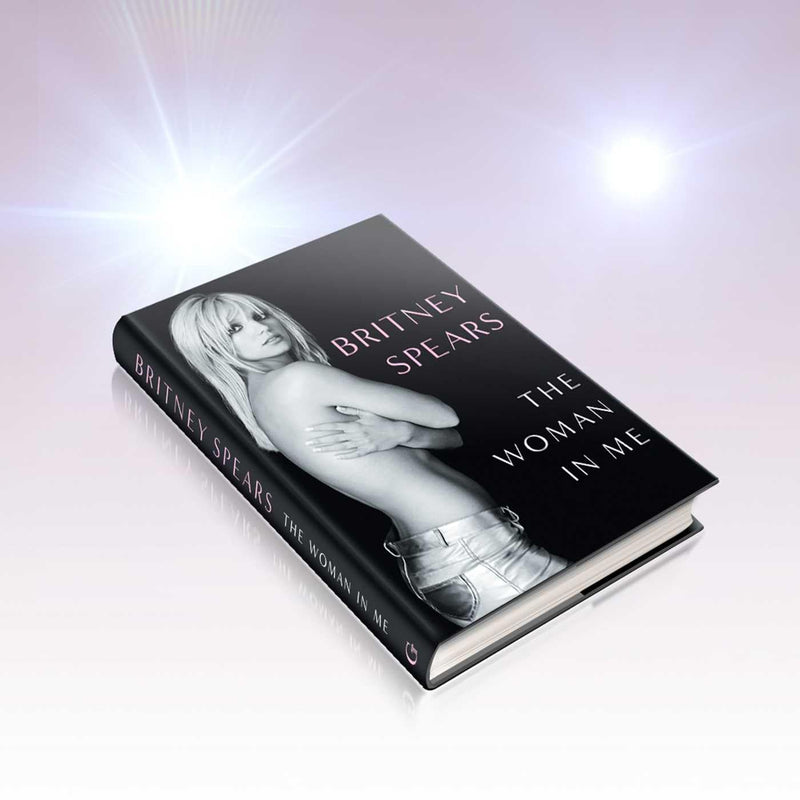 Hardcover copy of "The Woman in Me" autobiography by Britney Spears with a cover image featuring Britney Spears' portrait.