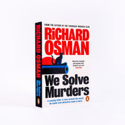 Paperback of "We Solve Murders" by Richard Osman, a bestselling murder mystery novel with a Penguin cover.