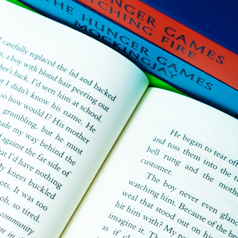 Four paperback books from Suzanne Collins' Hunger Games series by Scholastic, featuring cover art from the box set collection.
