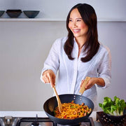 Paperback of Eat Clean: Wok Yourself to Health cookbook by Ching-He Huang, featuring colorful wok and fresh vegetables on the cover.