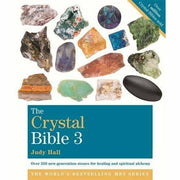Open pages of The Crystal Bible 3 Books Collection set by Judy Hall, non-fiction paperback on crystals and healing.