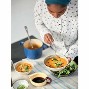 Hardcover of Nadiya Hussain's "Nadiya's Family Favourites" cookbook featuring colorful dish photos and recipe pages.