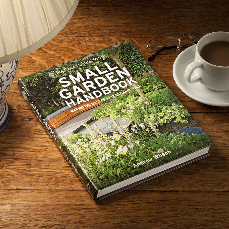 Hardcover of RHS Small Garden Handbook by Andrew Wilson, showcasing the book cover with gardening tips for small outdoor spaces.