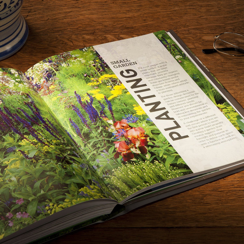Hardcover of RHS Small Garden Handbook by Andrew Wilson showcasing a garden scene with plants and gardening tools.
