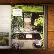 Hardcover of RHS Small Garden Handbook by Andrew Wilson, showing the book cover with garden illustrations and title.